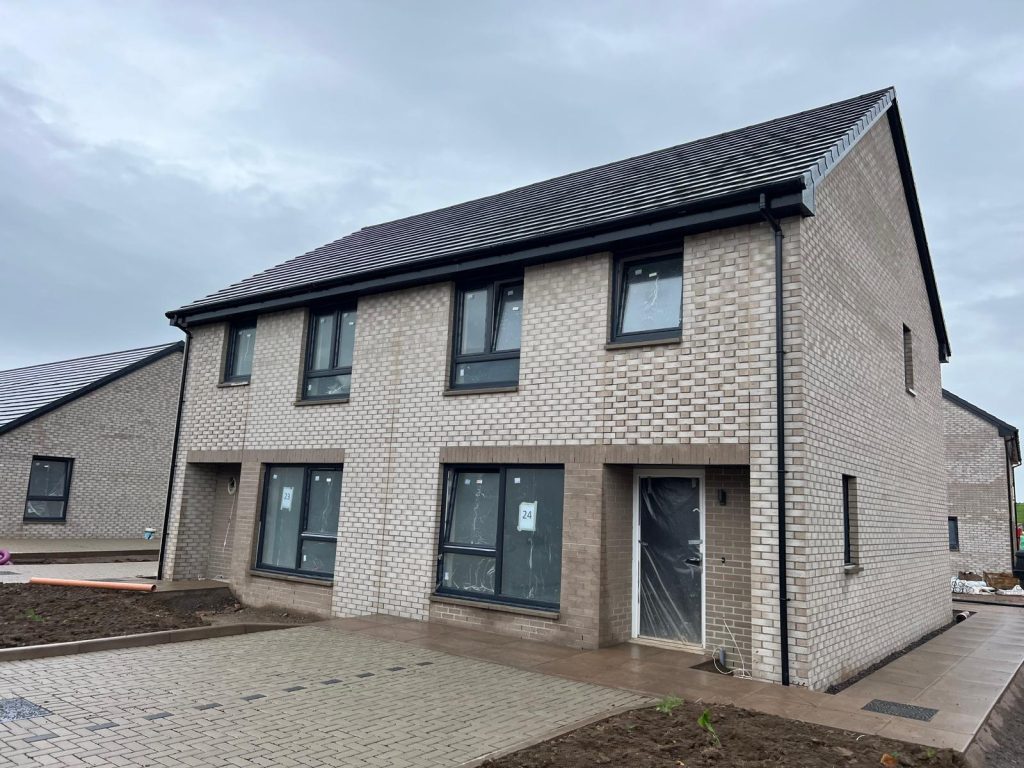 Newly built semi-detached homes at the Wheatley Development in Springholm, featuring energy-efficient designs and modern aesthetics, nearing completion.